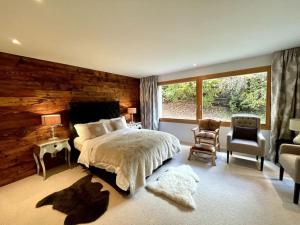 弗利姆斯Spacious Family Apt Flims close to Lake Cauma的带床和木墙的卧室
