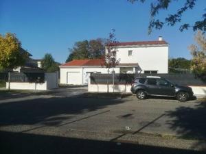 une voiture garée dans un parking en face d'une maison dans l'établissement Chambre et cuisine indépendante à 25 min du capitole, à Auzeville-Tolosane