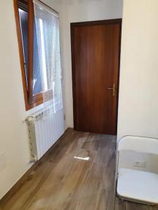 um quarto vazio com uma porta e um piso de madeira em Sweet Home Francesco & Chiara em Chioggia