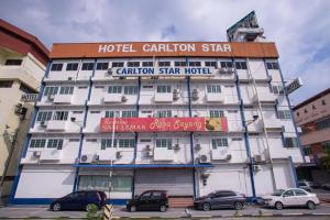 a hotel building with cars parked in front of it at Carlton Hotel Seremban - Next to Terminal Bus Station in Seremban