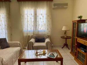 a living room with a couch and a tv at Igoumenitsa Retiré Apartment in Igoumenitsa