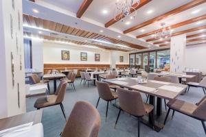 comedor con mesas y sillas en Kontakt Wellness Hotel en Stará Lesná