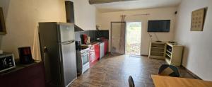 a kitchen with a refrigerator and a table in it at maison O jasmin in Lagnes