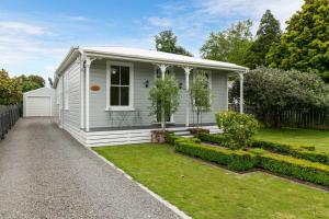 une petite maison blanche avec un jardin dans l'établissement Historic Charm in Greytown - Tranquil setting - walk to town, à Greytown