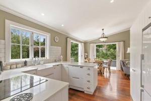 une cuisine avec des comptoirs et des fenêtres blancs ainsi qu'une salle à manger dans l'établissement Historic Charm in Greytown - Tranquil setting - walk to town, à Greytown