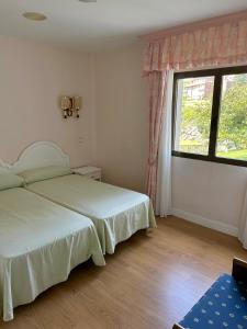 1 dormitorio con 2 camas y ventana grande en Hospedaje de La Hoz en Isla