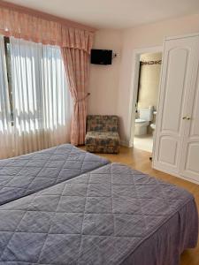 イスラにあるHospedaje de La Hozのベッドルーム(大型ベッド1台、椅子付)