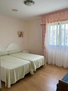 ein Schlafzimmer mit einem Bett und einem großen Fenster in der Unterkunft Hospedaje de La Hoz in Isla