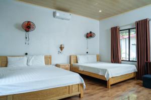 a bedroom with two beds and a window at Tran Chau Garden Home in Cat Ba