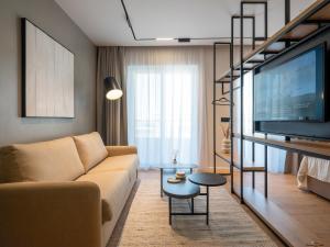 a living room with a couch and a flat screen tv at Space Row Design Living in Heraklio