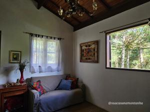 Una sala de estar con un sofá y una ventana. en ACasA sua cabana com banheira Lareira Starlink, en Gonçalves