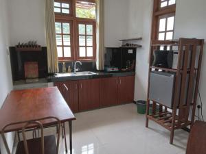 Metro Stay في كورونيغالا: مطبخ مع طاولة ومغسلة ومكتب