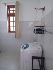 庫魯內格拉的住宿－Metro Stay，带窗户的客房内的洗衣机
