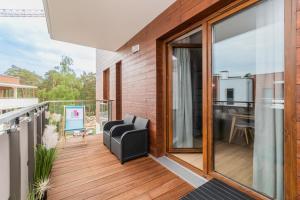 ステグナにあるApartament Stegna Mare 450m od plażyの木製のデッキに黒い椅子が置かれたバルコニー