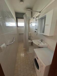 a white bathroom with a sink and a toilet at Complesso Mosaico NO PISCINA Per il Check in Agenzia Viale Francesco Petrarca 391 lido Adriano Ra in Lido Adriano
