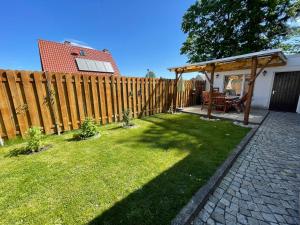 a backyard with a wooden fence and a picnic table at Ferienwohnung am Waldrand in Tharandt
