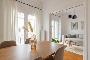 Sunny 2BR Apartment in Nea Smyrni by UPSTREET في أثينا: غرفة معيشة مع طاولة خشبية وأريكة