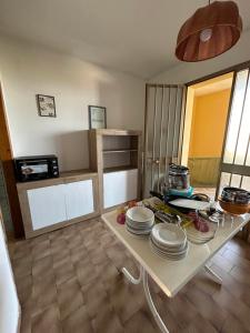 a kitchen with a table with plates on it at Complesso Mosaico NON FORNISCE BIANCHERIA DA LETTO,NON FORNISCE ASCIUGAMANI NON FORNISCE PRODOTTI IN GENERE, appartamenti arredati come da foto, Per il Check in Agenzia Ferro Viale Francesco Petrarca 391 lido Adriano Ra in Lido Adriano
