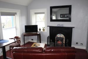 a living room with a couch and a fireplace at Studio flat - An Bonnan Bui in Rathmullan