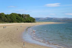 a group of people on a beach near the water at Studio flat - An Bonnan Bui in Rathmullan
