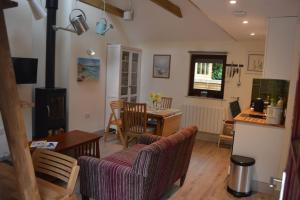 a kitchen and living room with a table and chairs at The Potting Shed Sopley in Christchurch