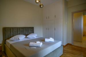 a bedroom with a bed with two towels on it at Luxury Modern 2 bed Elegance in Athens