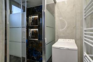 a bathroom with a toilet and a glass shower at Luxury Modern 2 bed Elegance in Athens +16 photos