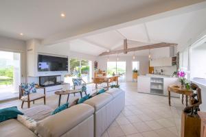 a living room with a large couch and a kitchen at Maison Madalena With Pool close to ocean 