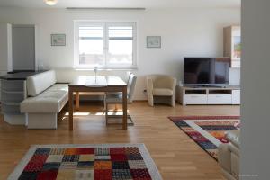 a living room with a couch and a table and a tv at Panoramablick Dobl in Dobl-Zwaring