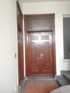 uma grande porta de madeira num quarto com escadas em Sultan Guest House Lahore em Lahore