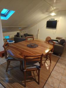 einen Holztisch und Stühle im Wohnzimmer in der Unterkunft Cascades de la mare à poule d'eau in Salazie