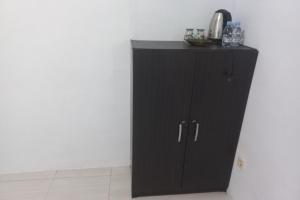 um armário preto no canto de um quarto em OYO 93900 Guest House Cinta Damai em Tegal