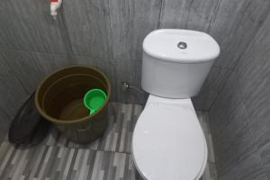 uma casa de banho com um WC branco e um balde em OYO 93900 Guest House Cinta Damai em Tegal