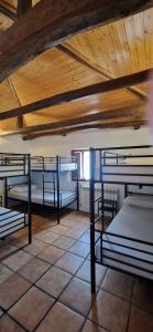 a room with three bunk beds and a wooden ceiling at Albergue Laganares 