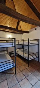 three bunk beds in a room with a wooden ceiling at Albergue Laganares 