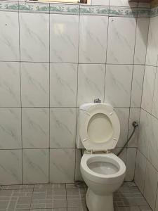 La salle de bains est pourvue de toilettes et d'un mur carrelé. dans l'établissement HA LUXURY Air b&b, à Kampala
