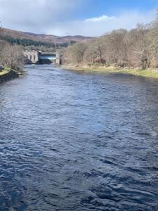a view of a river with a bridge in the background at Tummel View Pitlochry in Pitlochry