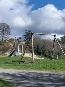 an empty playground with an old swing set on the grass at Tummel View Pitlochry in Pitlochry