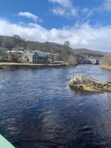 a river with a rock in the middle of it at Tummel View Pitlochry in Pitlochry