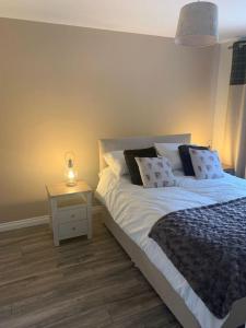 a bedroom with a bed and a night stand with a lamp at Tummel View Pitlochry in Pitlochry