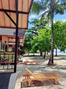 a group of picnic benches in front of a building at Beach House Penida in Nusa Penida