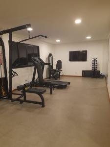 een fitnessruimte met loopbanden en een flatscreen-tv bij Buraquinho I Villas Praia Moderno e Aconchegante in Lauro de Freitas