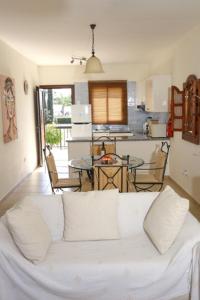 sala de estar con sofá blanco y cocina en Sunset Green 01, en Pafos
