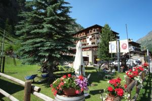 a fence with flowers and a tree and a building at Hotel Granta Parey in Rhêmes-Notre-Dame