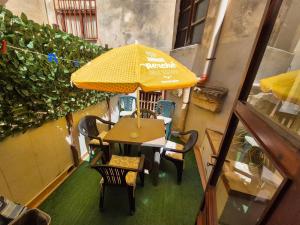 a table and chairs with an umbrella on a balcony at Apartment Trapani's heart in Trapani