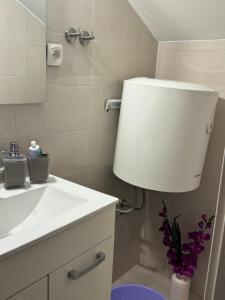a bathroom with a sink and a toilet and a lamp at Apartment Piko in Crikvenica