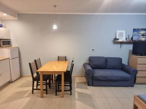 a living room with a table and a blue couch at Apartament Morskie Oko in Międzyzdroje