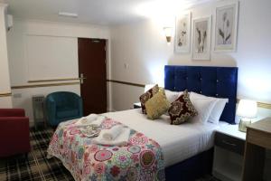 Una habitación de hotel con una cama con una bandeja de comida. en OYO 4 Sisters Inn, en Lincoln