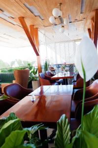 Hera Hotel Đà Lạt في دالات: قاعة المؤتمرات مع طاولة وكراسي والنباتات
