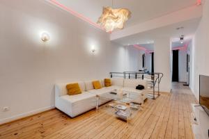 uma sala de estar com um sofá branco e uma mesa em Spacieux 90m2 Jacuzzi, Standing,Bien-être em Toulouse